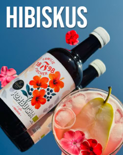 Zwei Flaschen mit Hibiskus-Etikett, ein Glas mit Getränk, Eiswürfeln, einer Birnenscheibe und Hibiskusblüten vor blauem Hintergrund.